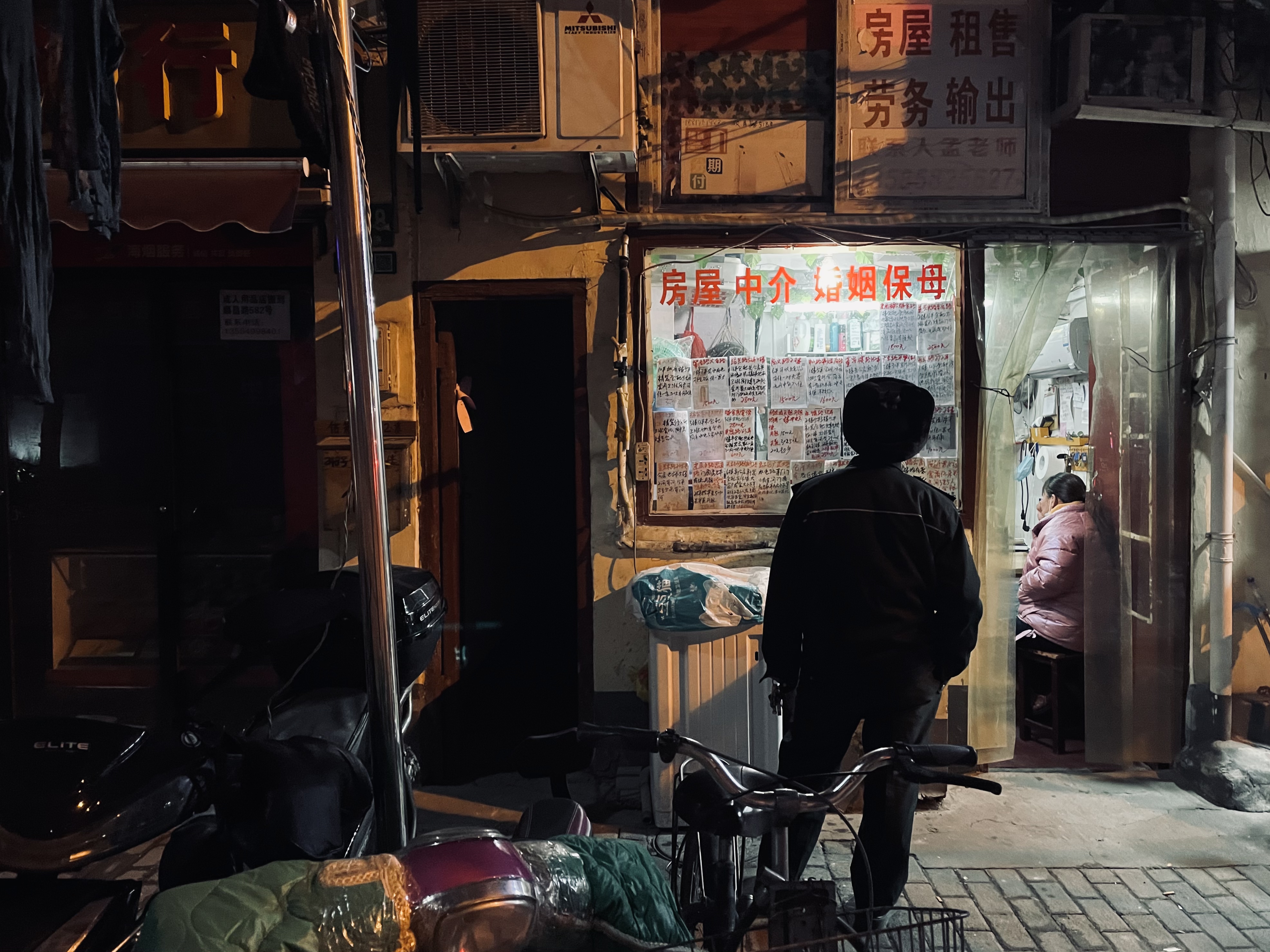 北京-尘 《寻觅》 iPhone，在上海老区的一条街，一位老先生在看中介店前的广告信息，可能是找房子、或者为家里找保姆。.jpg